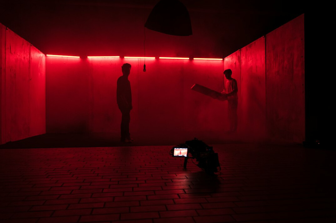 Television studio camera in a dark set with stage lighting