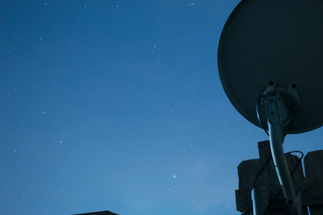 Satellite dish against a night sky used for signal transmission